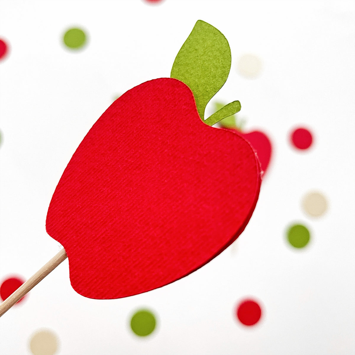Close-up of red cardstock apple cupcake topper with green leaf