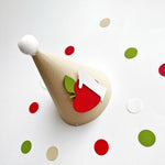 Apple theme 1st birthday cone hat surrounded by red and green table confetti