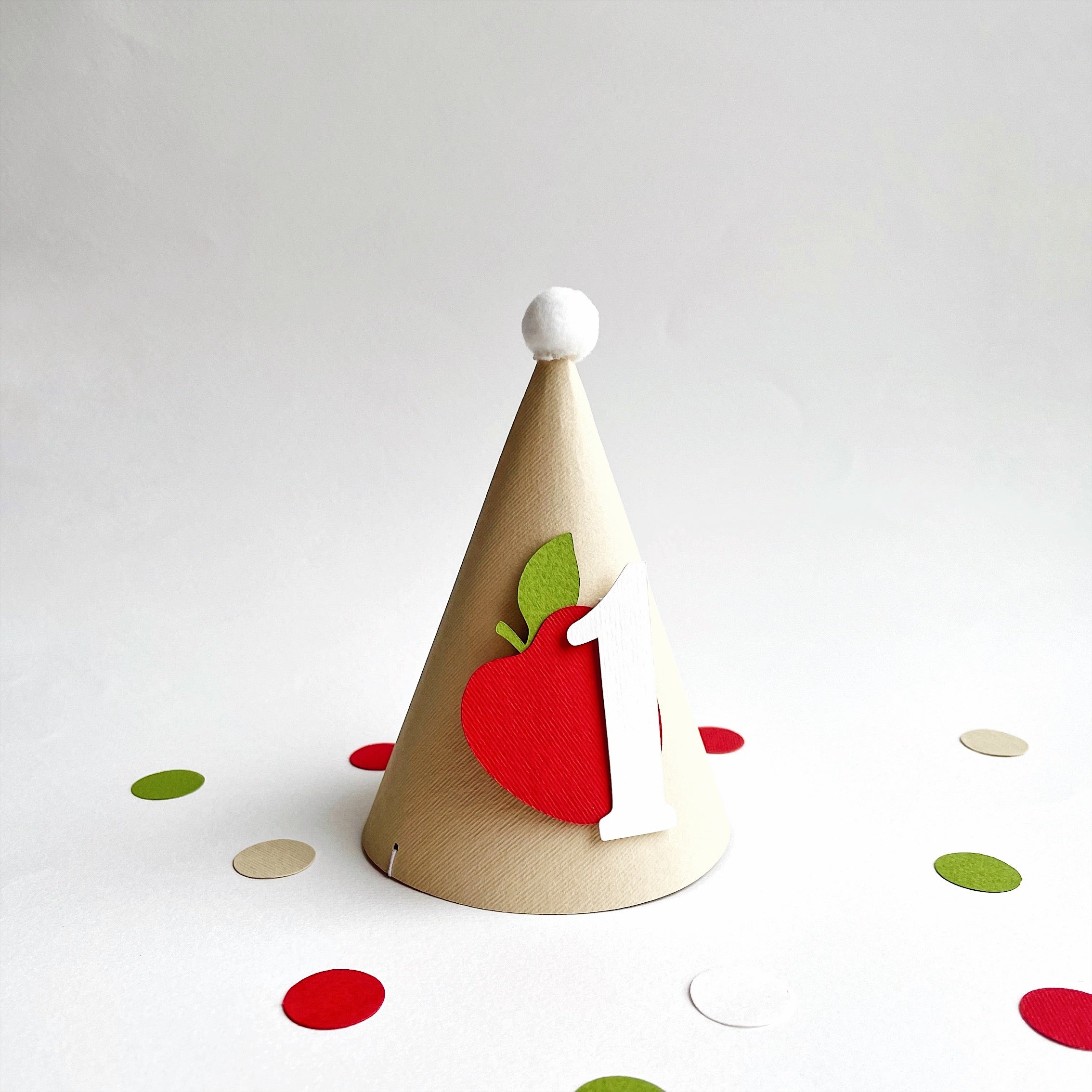 Handcrafted kraft cone party hat with red cardstock apple for cake smash session