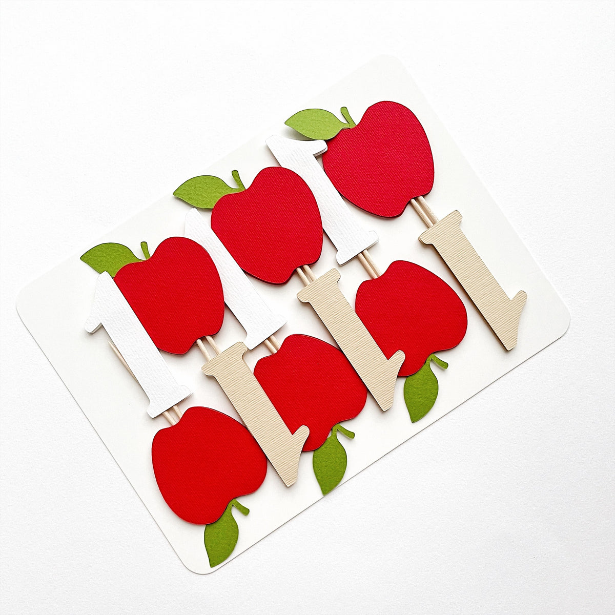 Handcrafted 1st birthday apple cupcake toppers mounted on display card