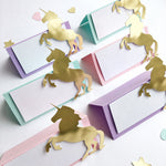 Gold unicorn decorations on colorful place cards with a white background