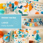Under the Sea Ocean Birthday Kit with a "Happy Birthday" banner, an One highchair banner, cupcake toppers with seahorses, crabs, and sharks, blue and green confetti, a party hat with shell accents, a paper garland and cake topper  with fish and octopus shapes.
