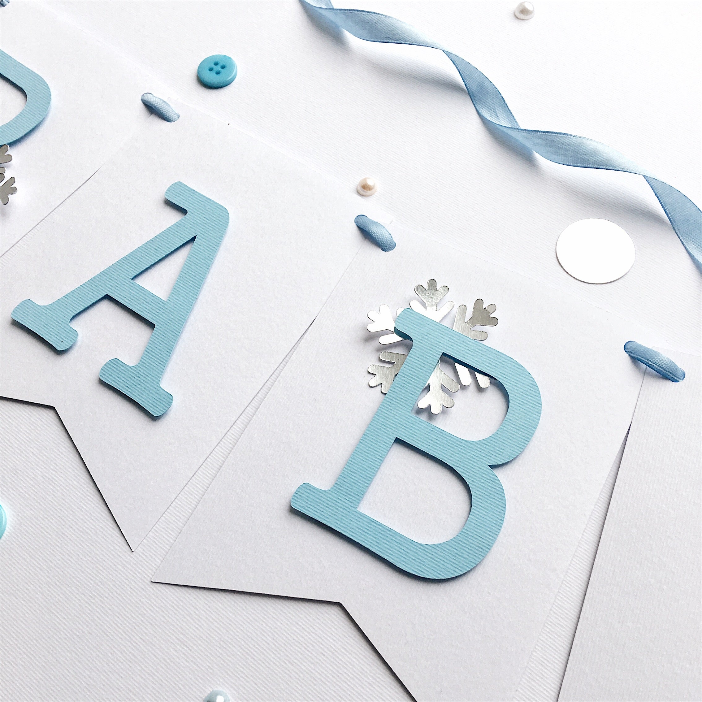 Polar Bear Baby Shower Name Banner in white and dusty blue for a winter gender reveal party.