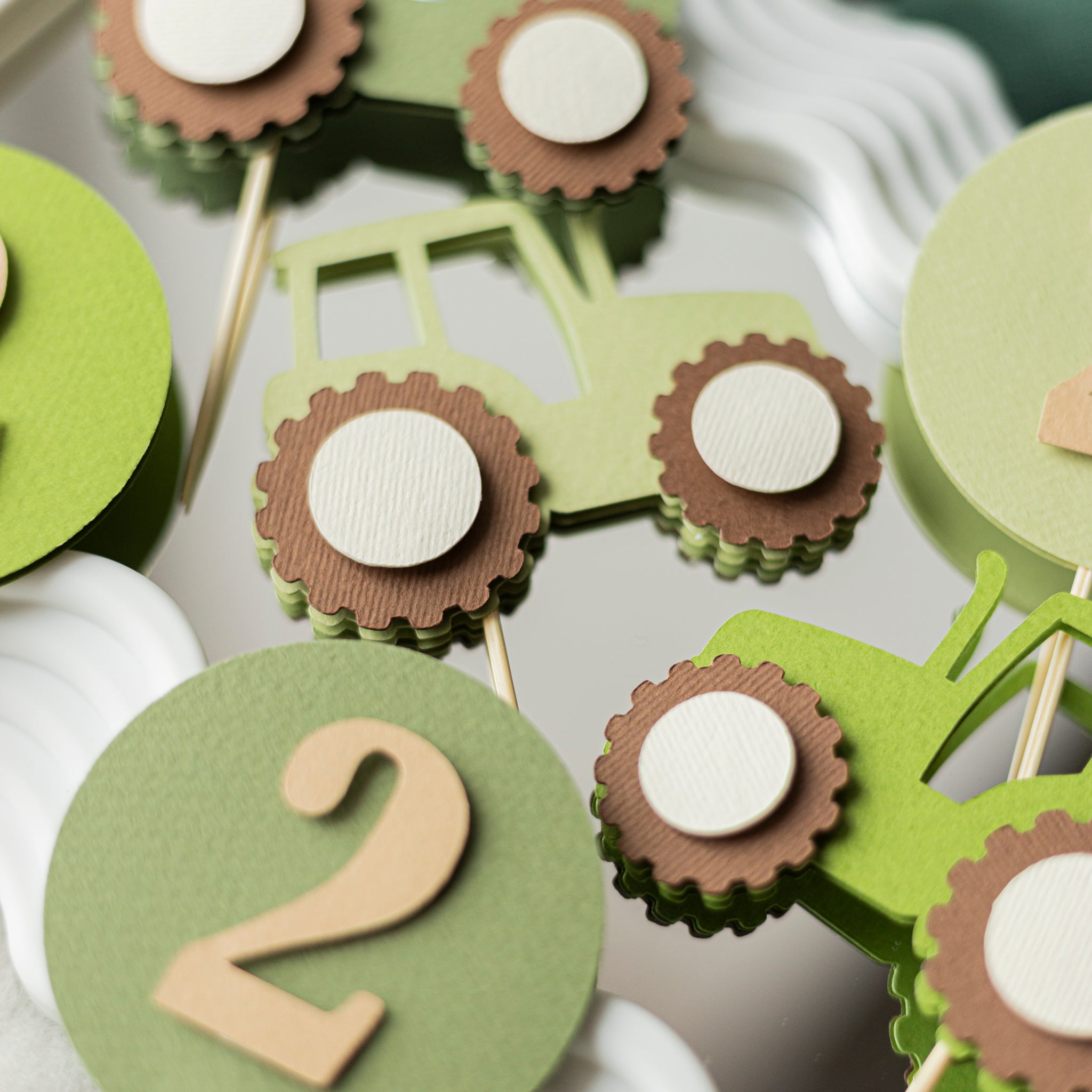 Close up detail of high quality cardstock tractor cupcake topper showing green and brown farm design