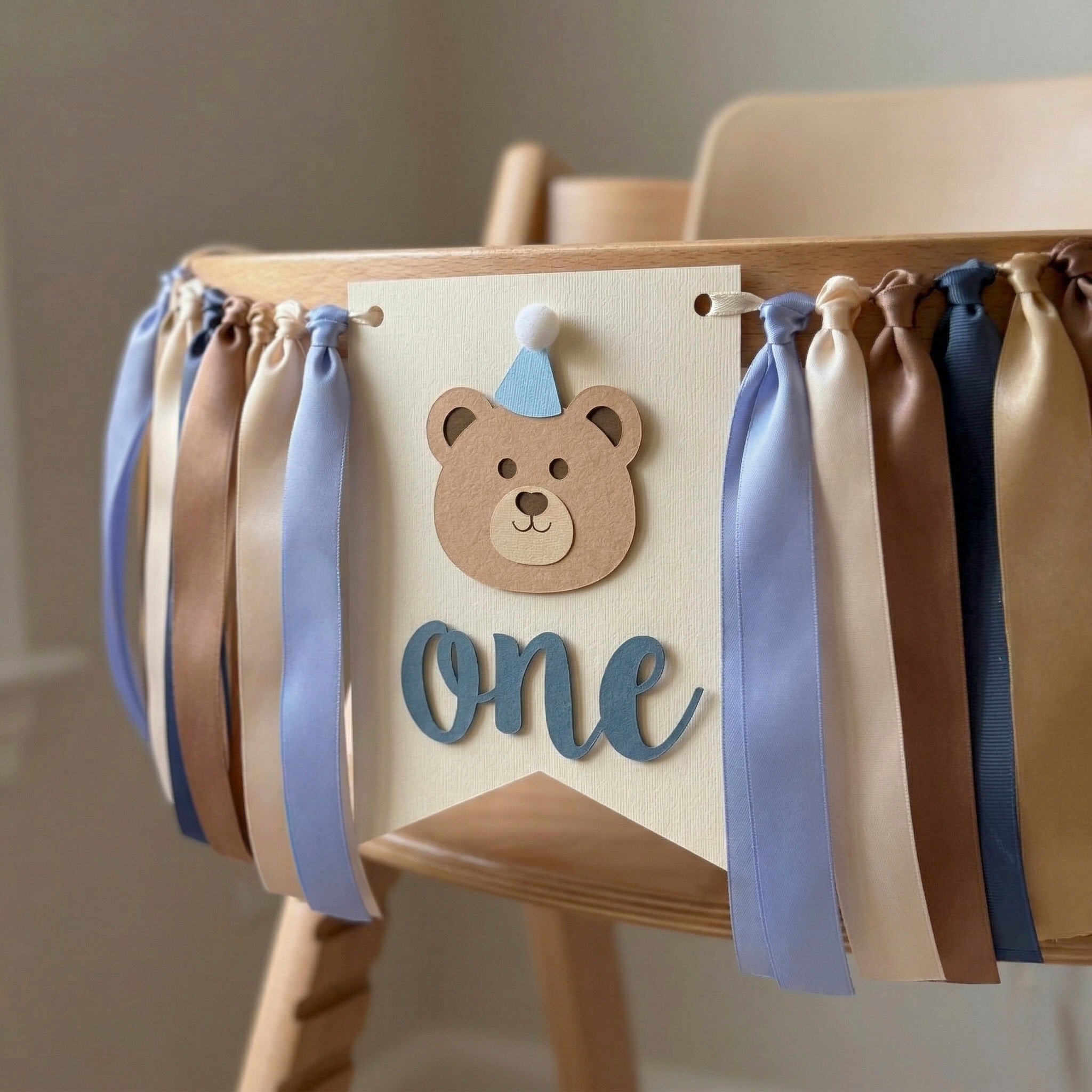 Teddy bear themed 1st birthday highchair garland on a wooden high chair for a beary first birthday cake smash photoshoot.