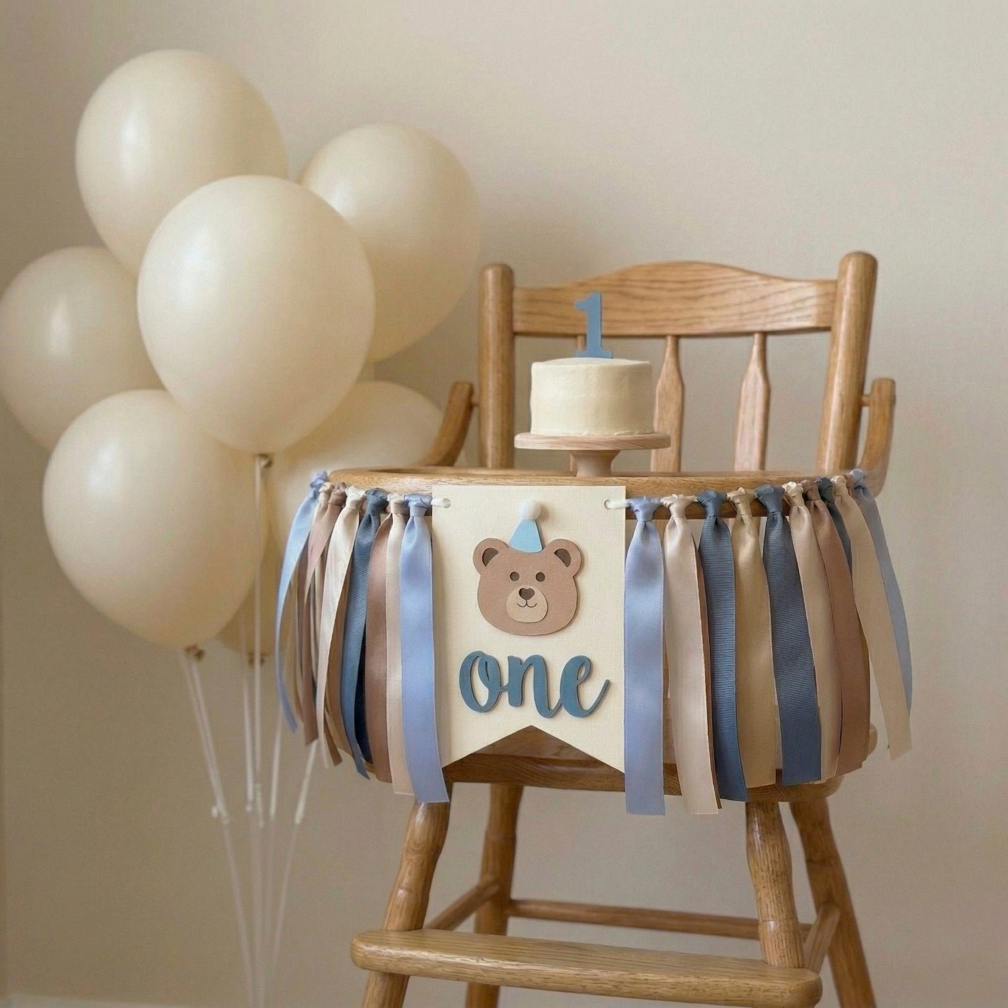 Teddy bear themed 1st birthday highchair garland on a wooden high chair for a beary first birthday cake smash photoshoot.