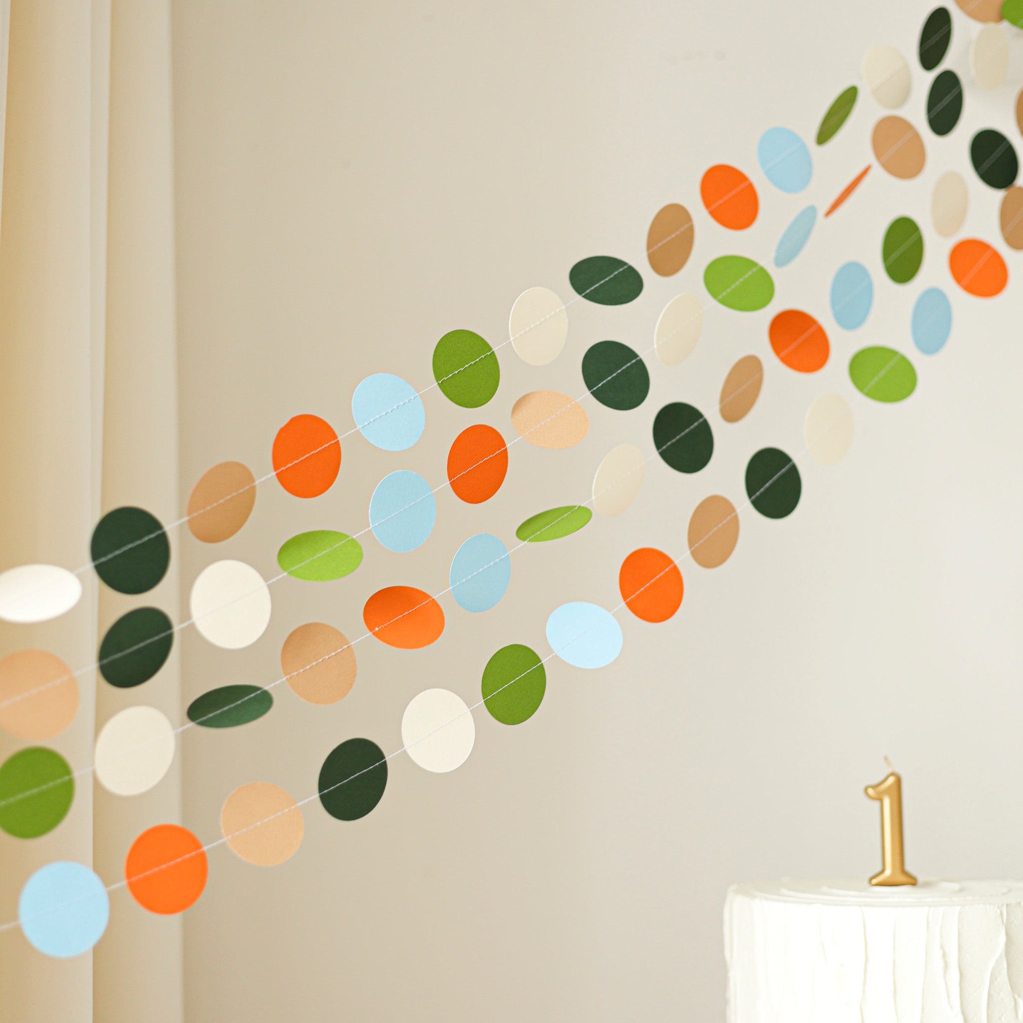 Modern dinosaur circle garland draped over a crib or shelf as neutral-colored nursery wall decor.