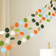 Modern dinosaur circle garland draped over a crib or shelf as neutral-colored nursery wall decor.
