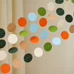 Close-up detail of high-quality matte cardstock circles and white stitching on a T-Rex birthday party garland.