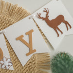 Winter banner with deer silhouettes and snowy background.