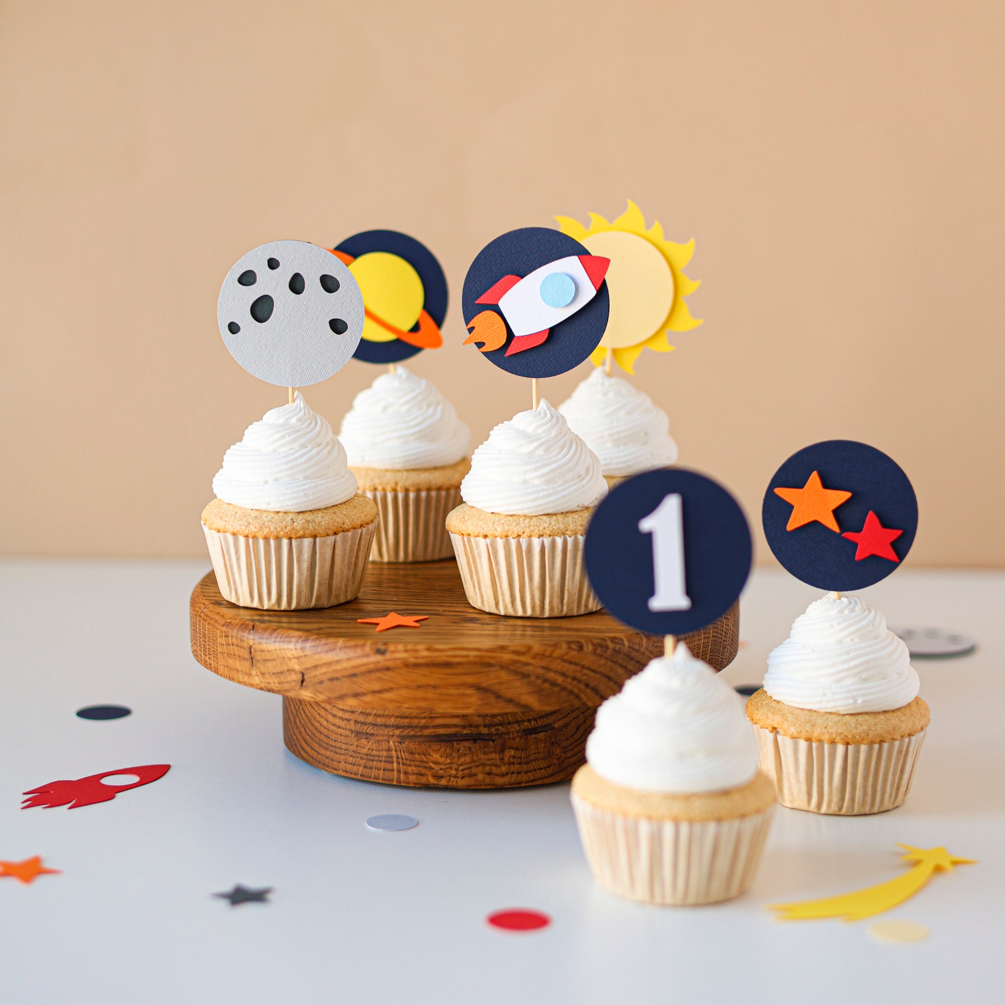 Space-themed 1st birthday cupcake toppers featuring a rocket ship, celestial stars, and solar system designs for a boy's first trip around the sun party.