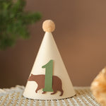 Handmade woodland bear first birthday party hat in cream with sage green number one and tan pom-pom.