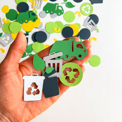 Close-up of 100% handmade recycled-themed party decorations featuring custom-colored truck and trash can confetti.
