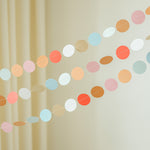 Colorful paper garland hanging against a beige curtain