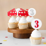 Cupcakes with fire truck toppers on a wooden stand 