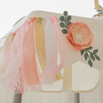 Decorative headboard with pink floral and tassel design on a white background