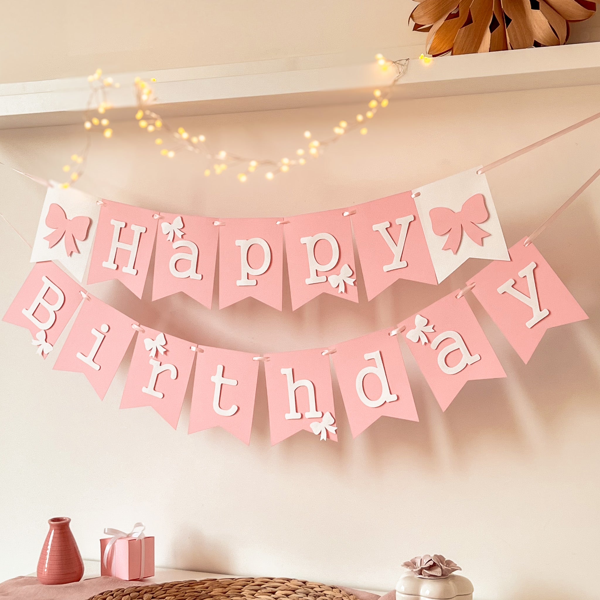 Handcrafted pink paper banner flag with bow accents and fairy lights