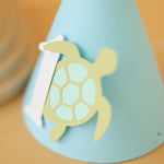 Light blue party hat with a turtle design and number '1' for baby boy ocean 1st birthday party