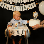 Child celebrating his first birthday with Space theme highchair banner and 1st Trip Around the Sun cake topper