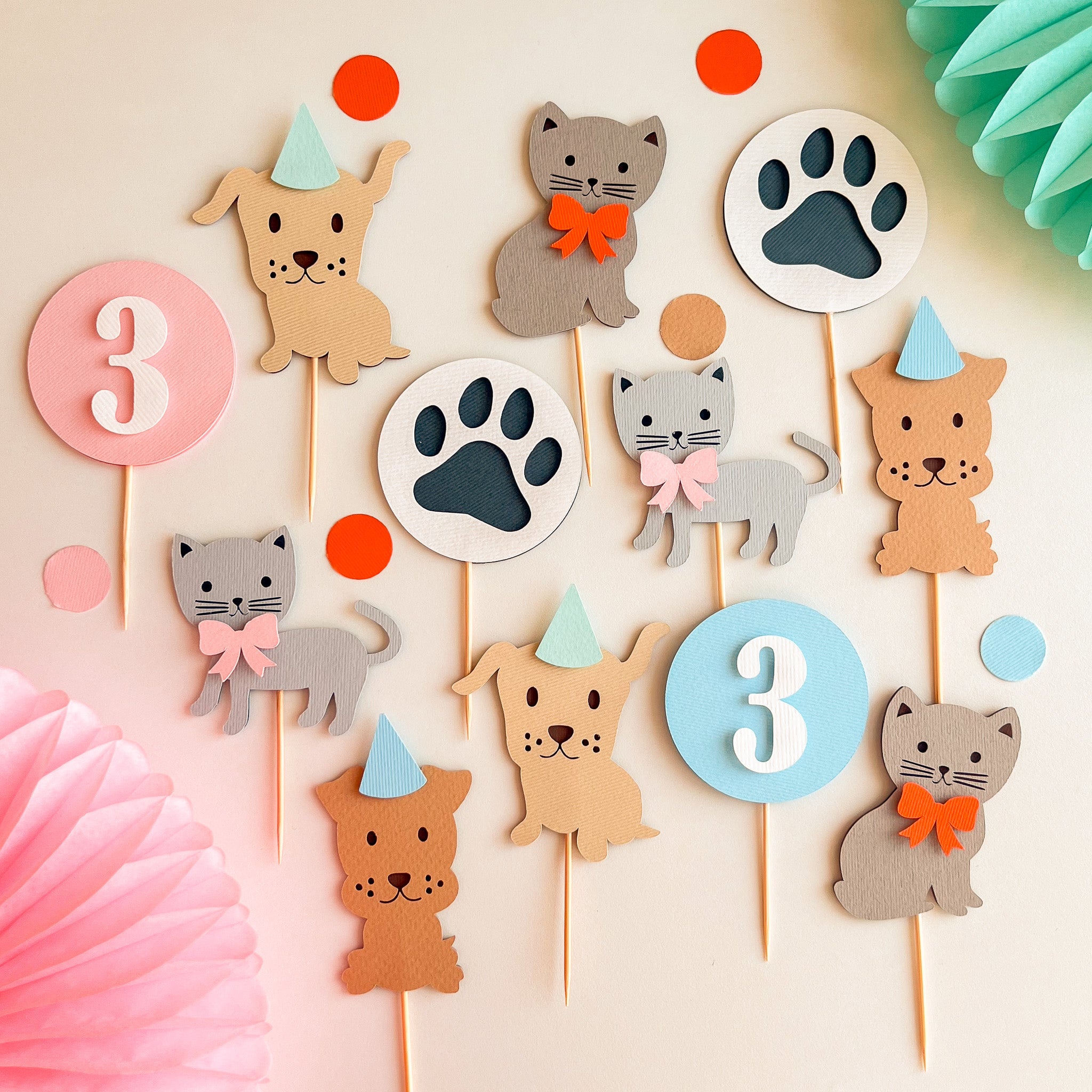 A set of cute animal party cupcake toppers featuring cartoon dogs, cats, and paw prints, decorated with pastel colors and party hats