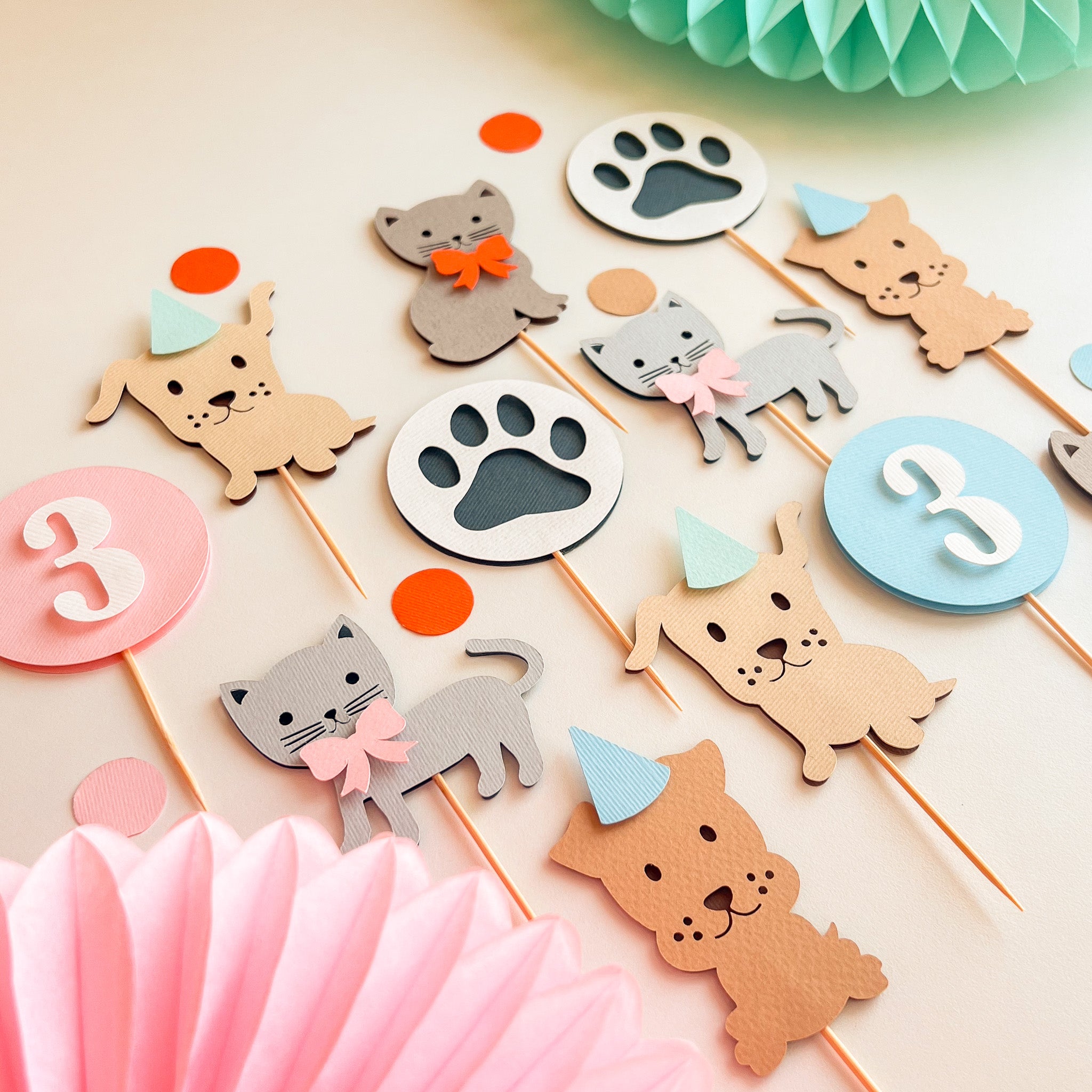 A set of cute animal party toppers for a  birthday, including cat and dog figures, paw print signs, and number circles