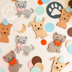 Colorful paper cutouts of cats and dogs with party hats and bows