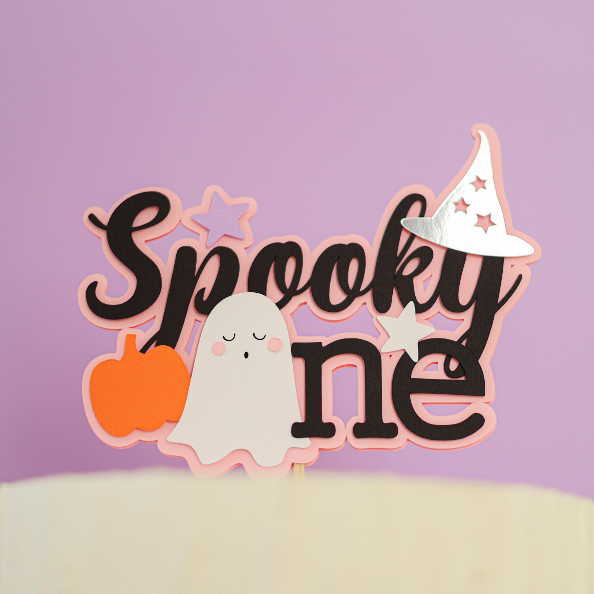 Halloween themed cake topper with ghost, pumpkin, and witch hat for celebrating 1st Birthday 
