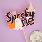 Halloween themed cake topper with 'Spooky One' text, ghost, and pumpkin for celebrating 1st Birthday 
