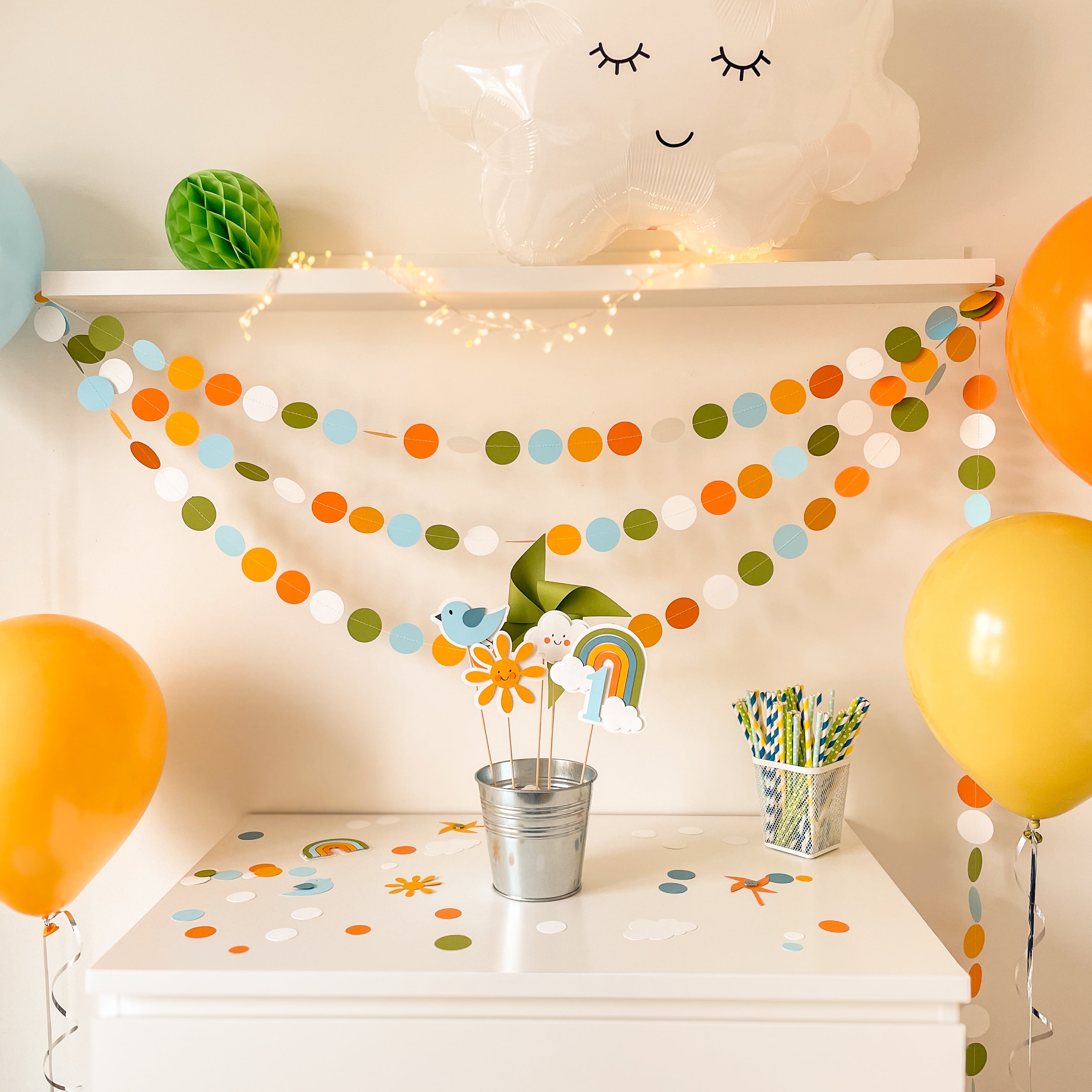 Children's party setup with balloons, streamers, and decorations on a shelf.