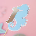 Pastel blue seahorse wrapped around a silver foil number 1 centerpiece stick for under the sea 1st birthday party