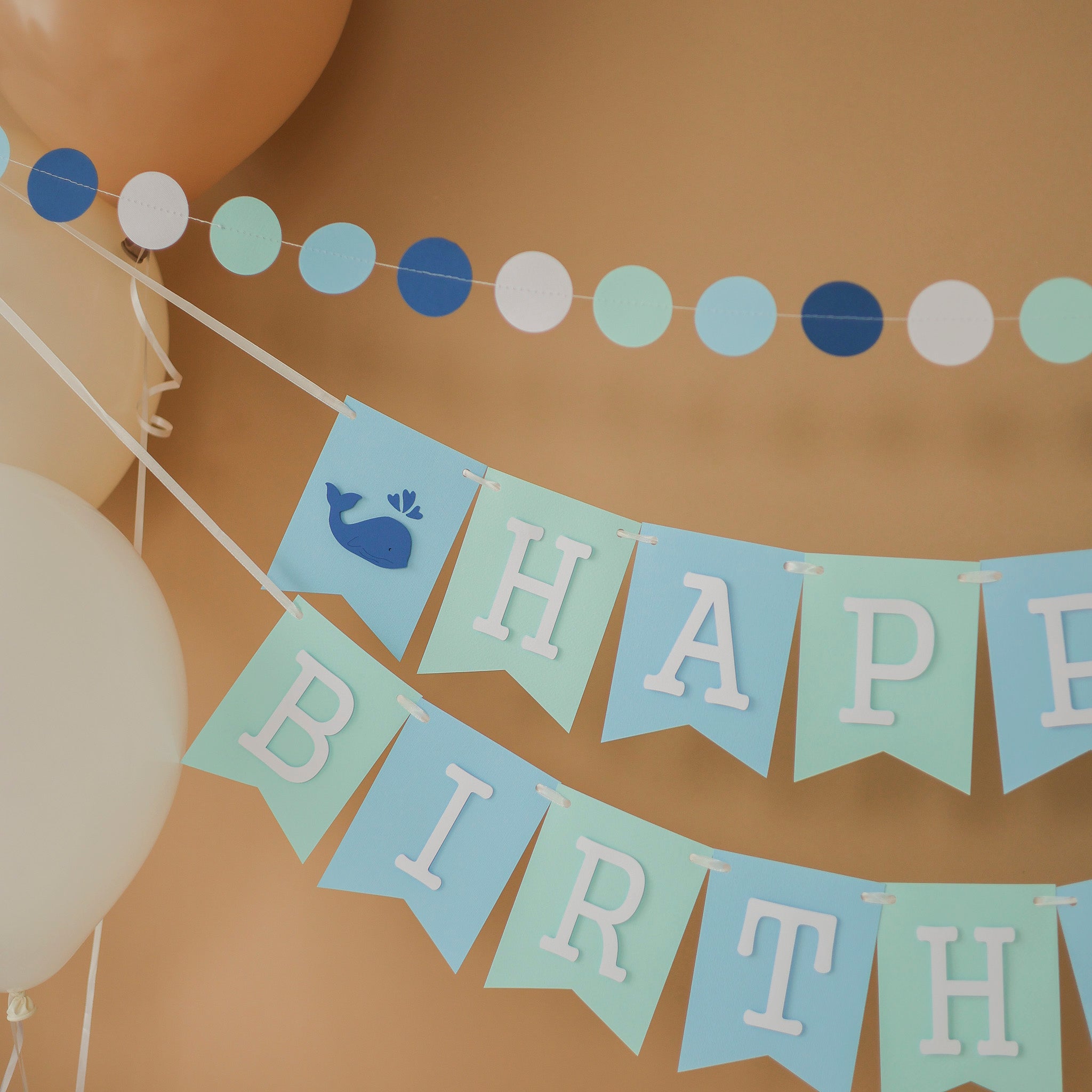 Handmade blue and mint whale birthday banner for a nautical themed first birthday party.