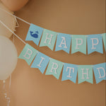 Handmade blue and mint whale birthday banner for a nautical themed first birthday party.
