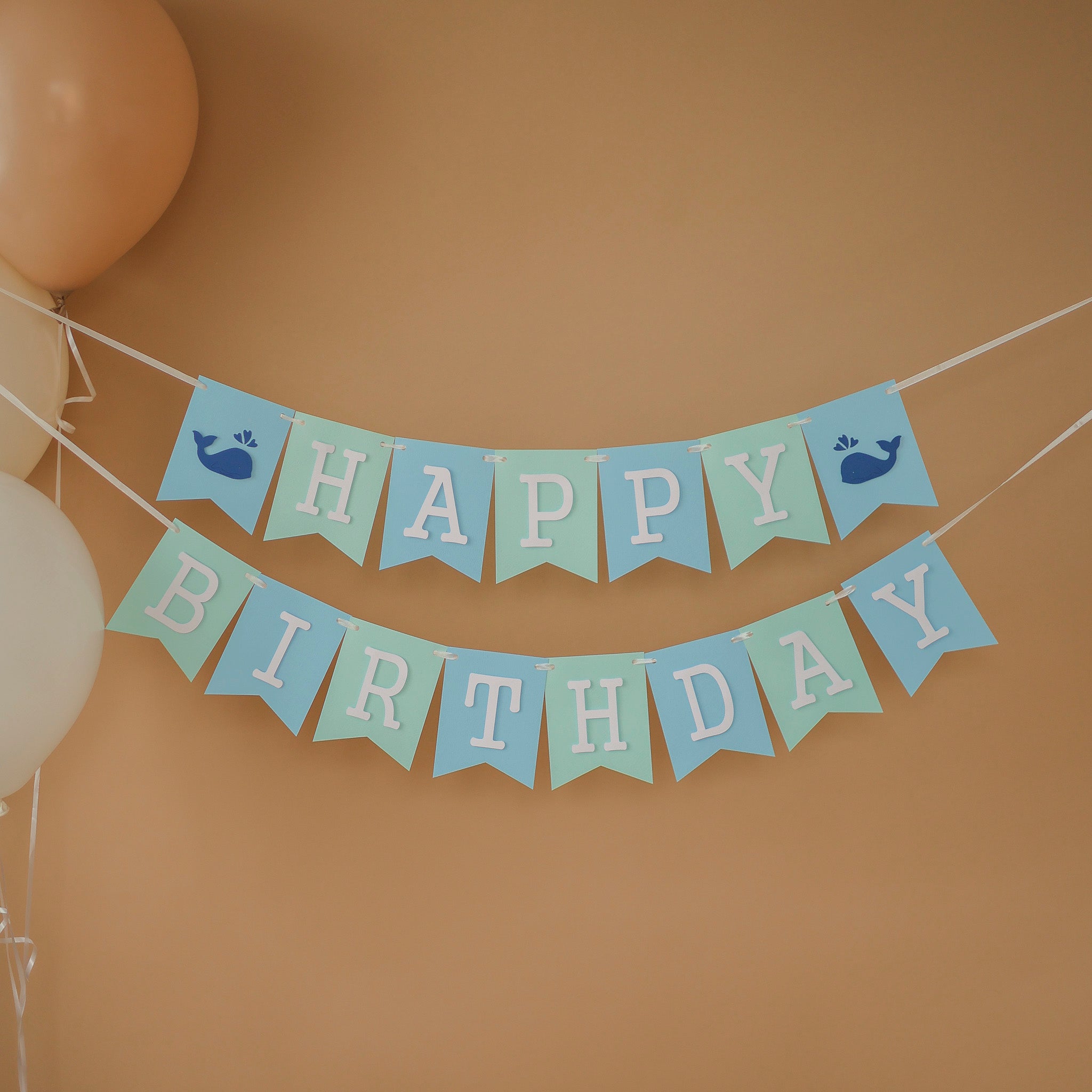 Handmade blue and mint whale birthday banner for a nautical themed first birthday party.