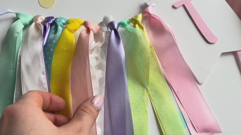A pastel birthday banner spelling 'TWO' with a donut decoration