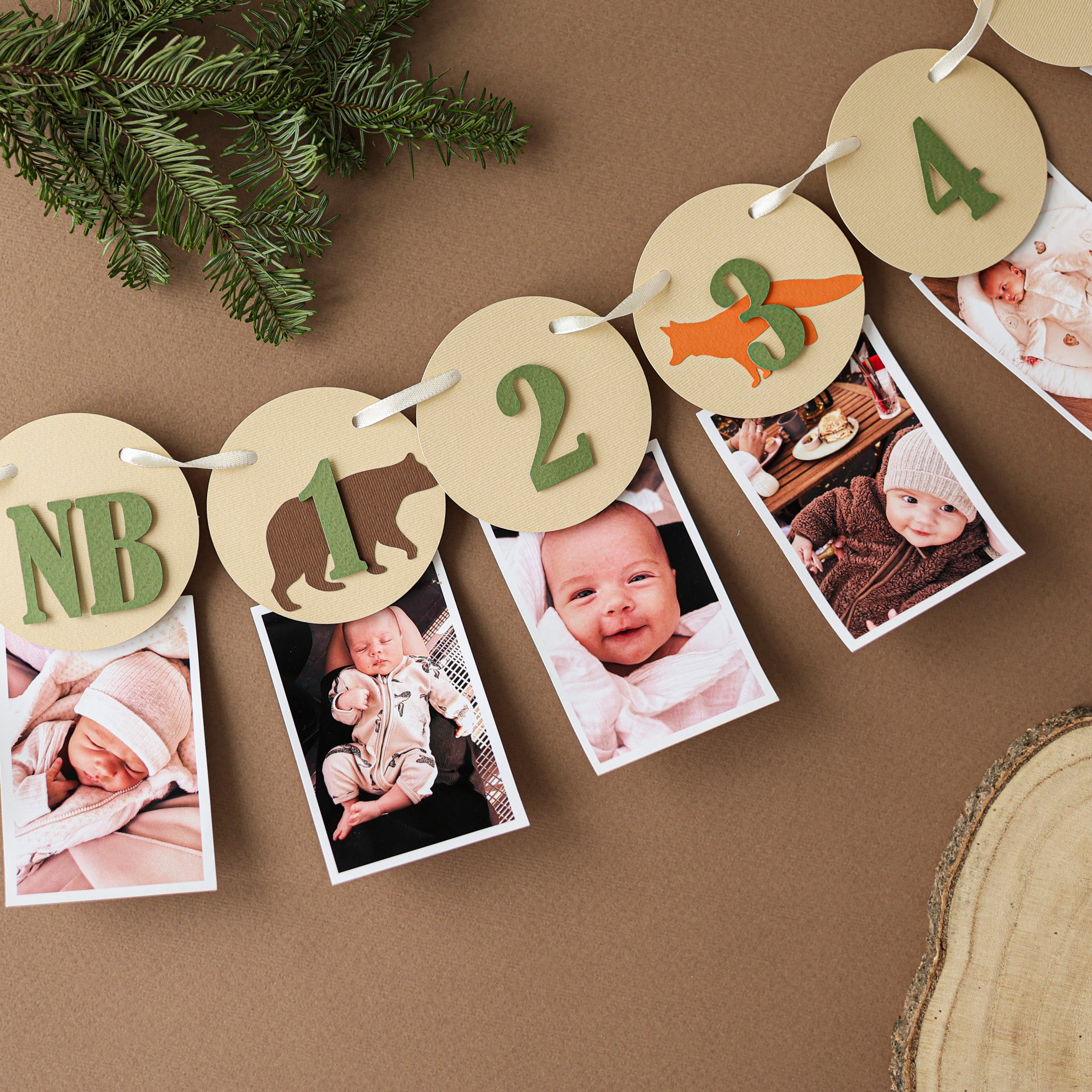 Woodland 12 month photo banner with forest animals and sage green numbers on Kraft paper circles for a baby's first birthday milestone display.