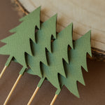 Woodland animal cupcake toppers for a forest baby shower or wild one birthday, featuring paper cutouts of bears, foxes, moose, and pine trees in earthy tones.