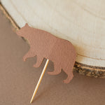 Brown bear-shaped cupcake topper on a textured surface