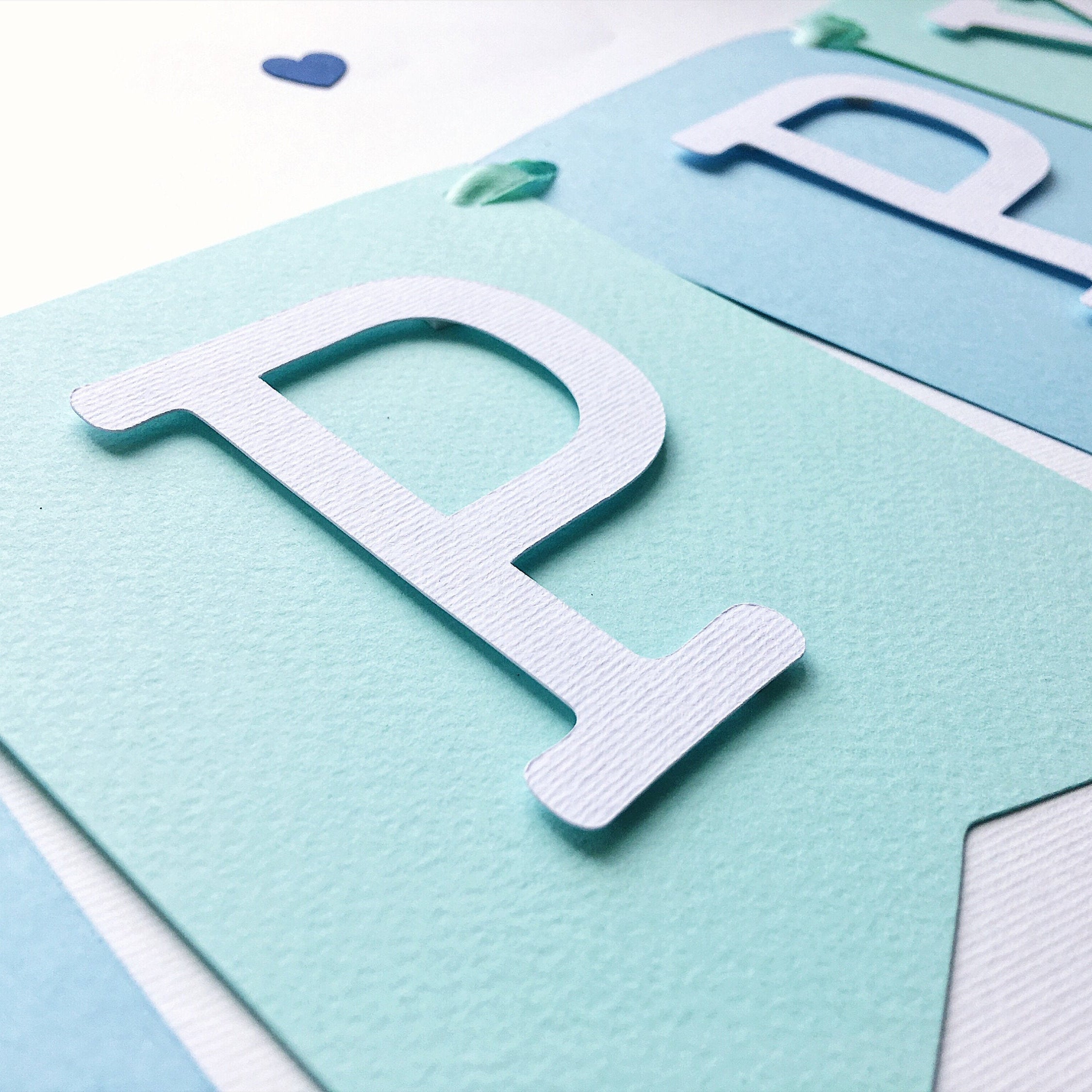 Handmade blue and mint whale birthday banner for a nautical themed first birthday party.